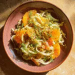 Nahaufnahme von Fenchel Orangen Salat mit Orangenscheiben, Dill und Pistazien auf Keramikteller