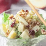 Chicorée Salat mit Apfel, Walnüssen und Rosinen angerichtet in Glasschüssel